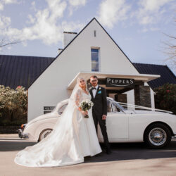 Bride and groom with wedding car